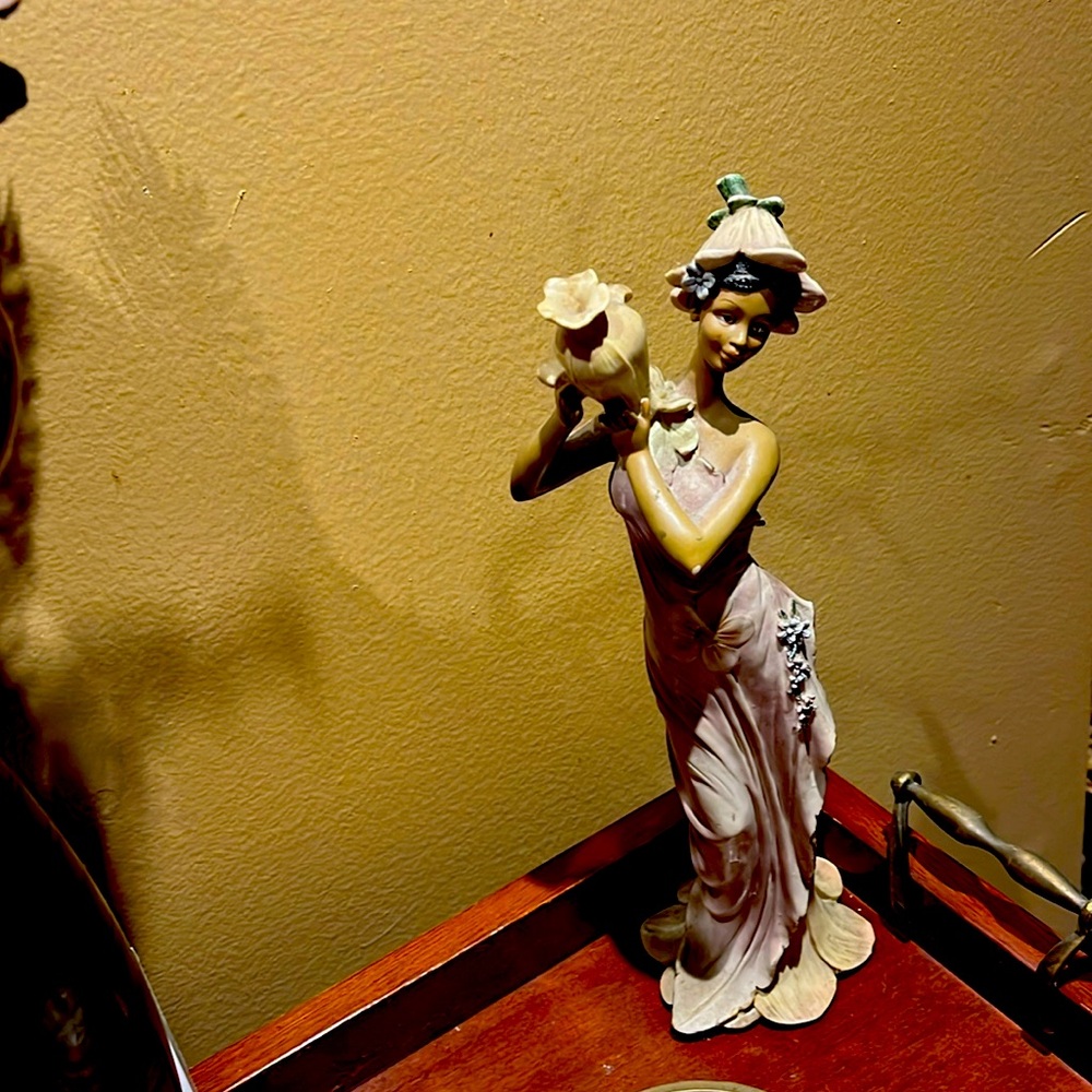 Statue of pretty light brown lady carrying vase or maybe water?